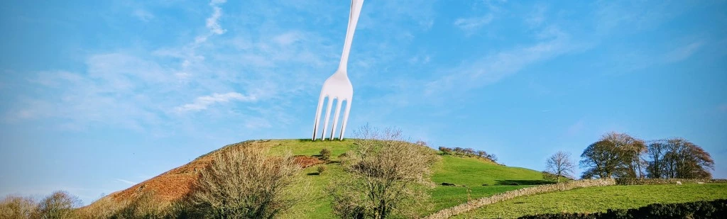 A giant table fork stuck in a hill